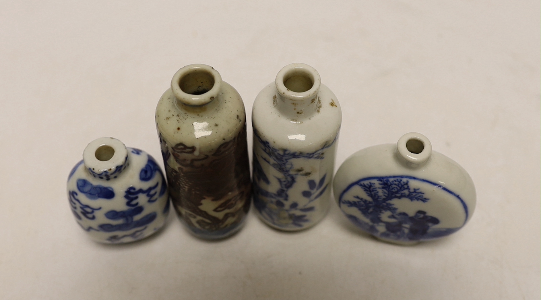 Three 19th century Chinese blue and white snuff bottles, and a similar underglaze blue and copper red Dragon snuff bottle, tallest 8cm